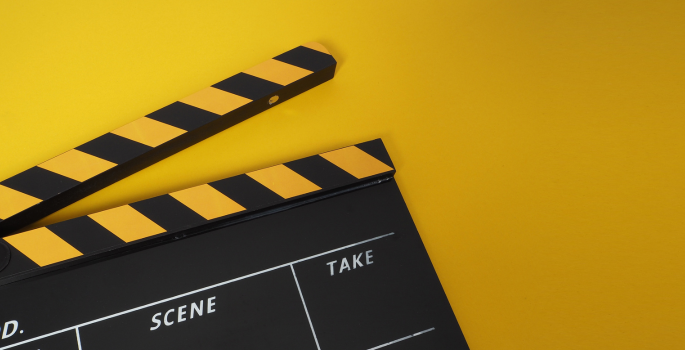 A film clapper on a yellow background