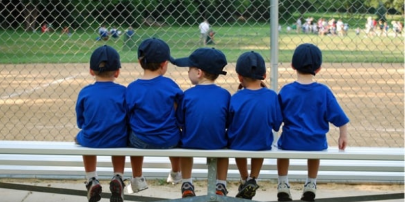 Little boys sitting in the dugout