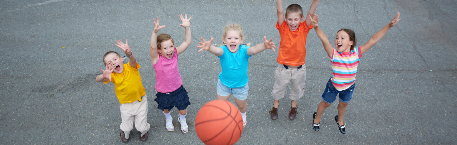 children on blacktop with basketball