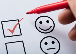 check box with happy and unhappy face, red pen used to check happy face