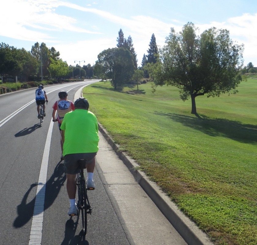 Cyclists in bike lane on country road.