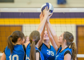 Volleyball players holding up a volleyball