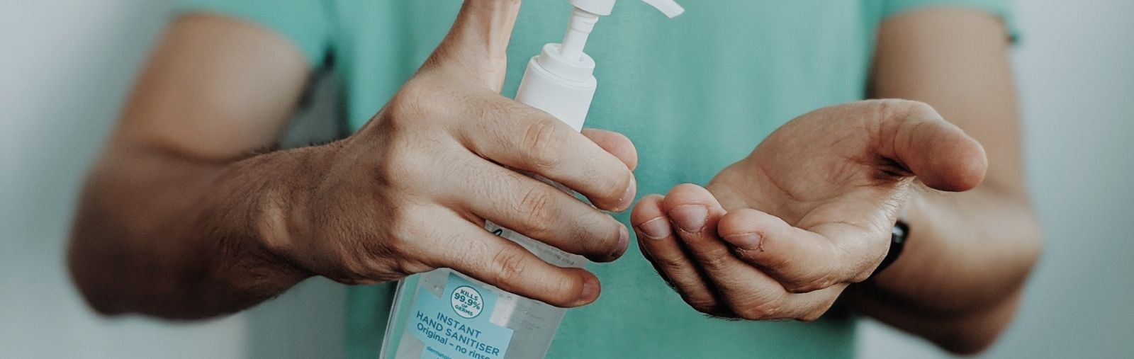 A man dispensing hand sanitizer into his hands