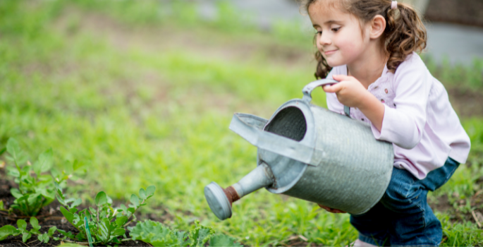 Girl water plant with watering can.