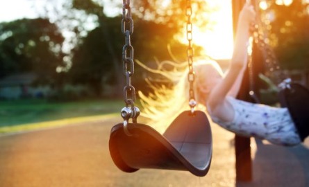 stock photo of child on a playground swing
