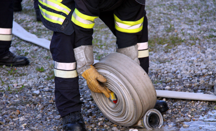 Fire volunteer unrolling hose