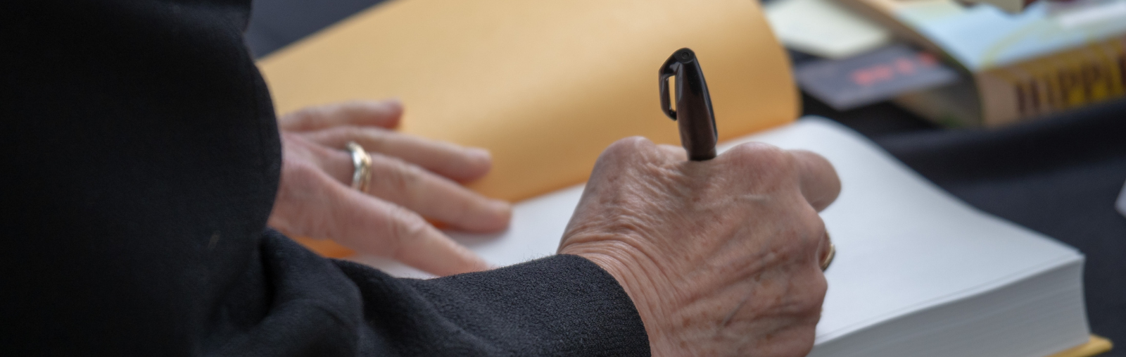 A man signing the front page of a book