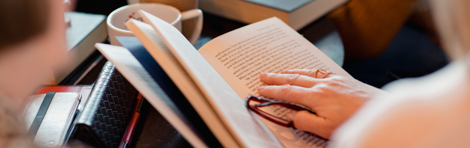 A close up of a book held by a woman sitting in a group