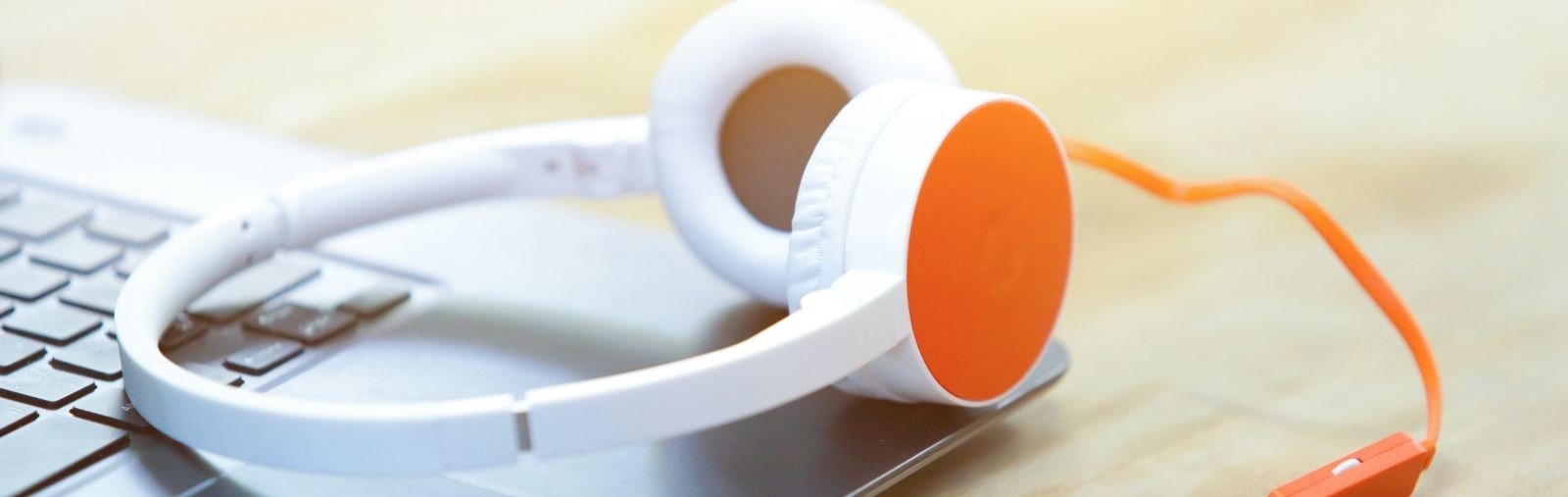 A pair of orange headphones on a laptop