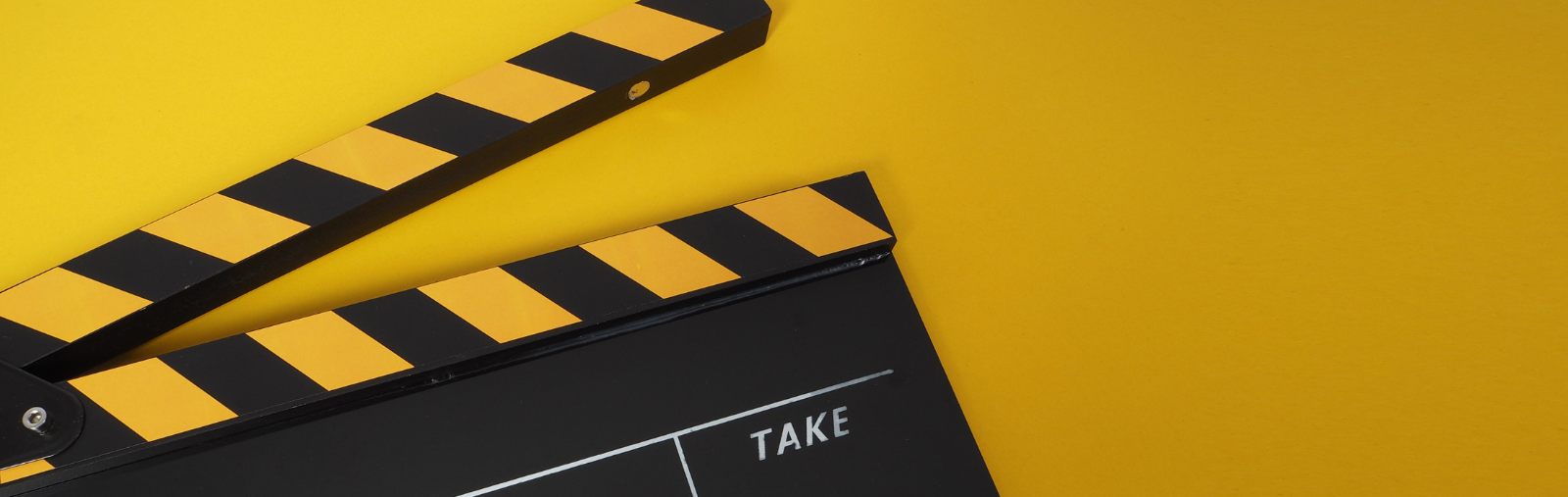 A film clapper on a yellow background