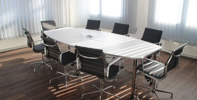 An empty conference table surrounded by chairs