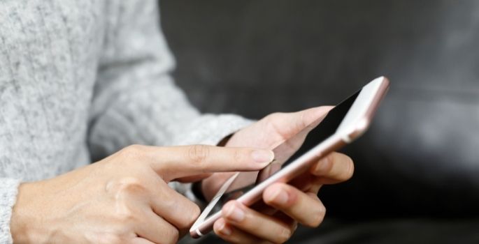 A detail of a woman typing on a smartphone