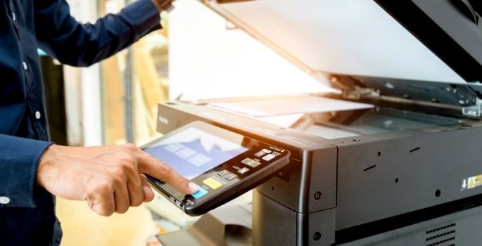 A man typing on a professional copier