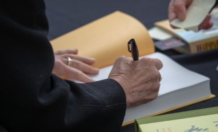 A man signing the front page of a book