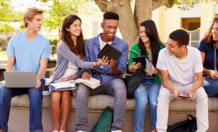 Teenagers laughing and sharing phones