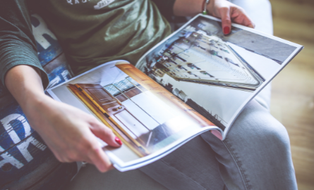 A person reading a magazine in their lap