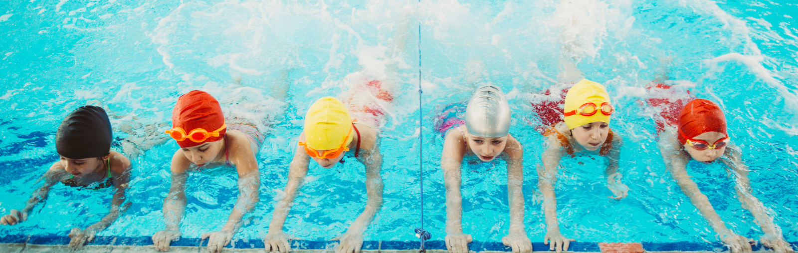 Child swimmers practicing kicks