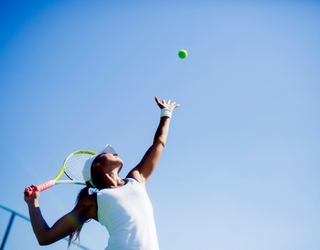 Woman serving a tennis ball