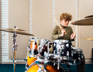 Young boy playing a drumset 