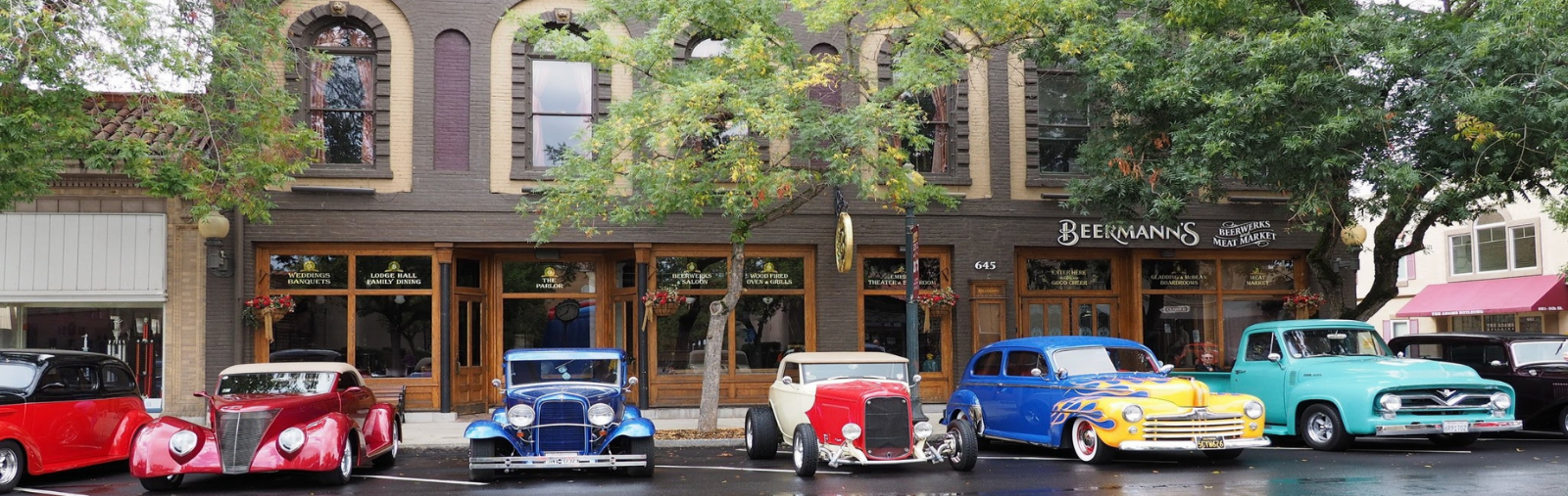 street scene with cars lined up for car show 