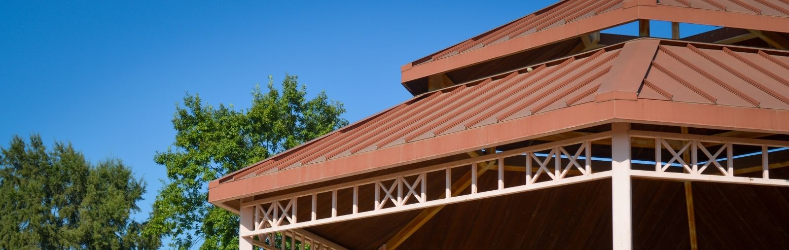 Red roof with blue sky and green trees