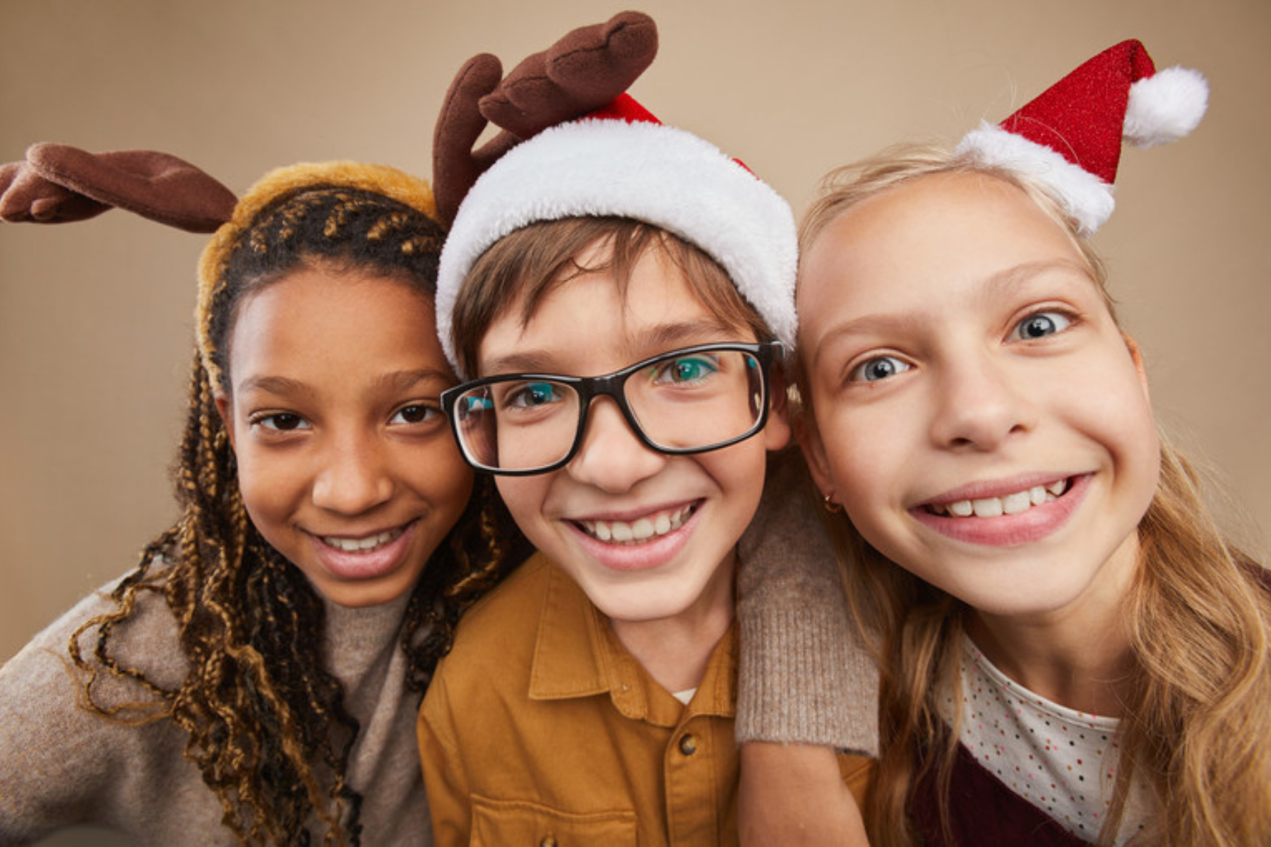 Kids wearing holiday hats and laughing