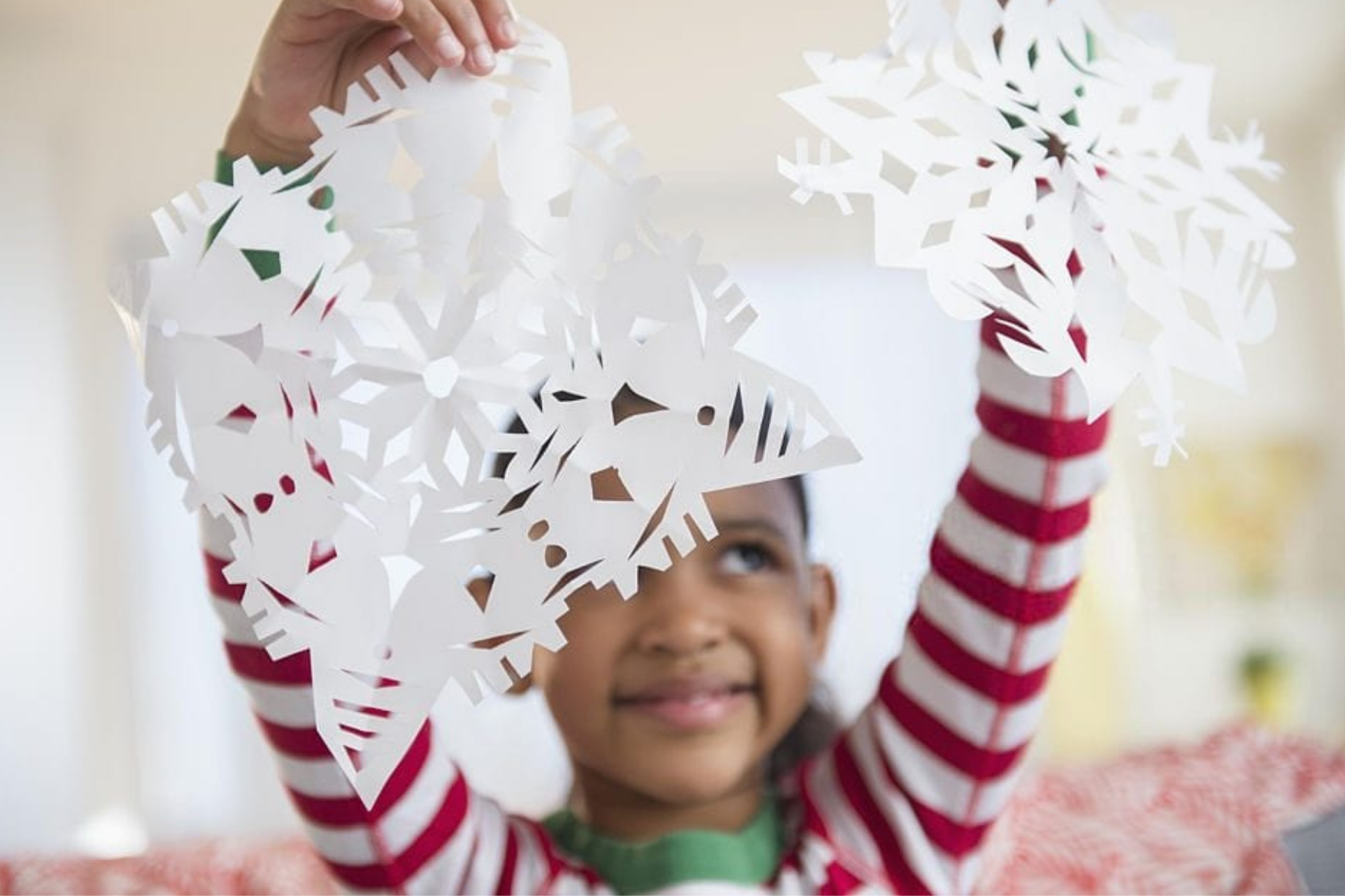 Young girl making paper snowflakes