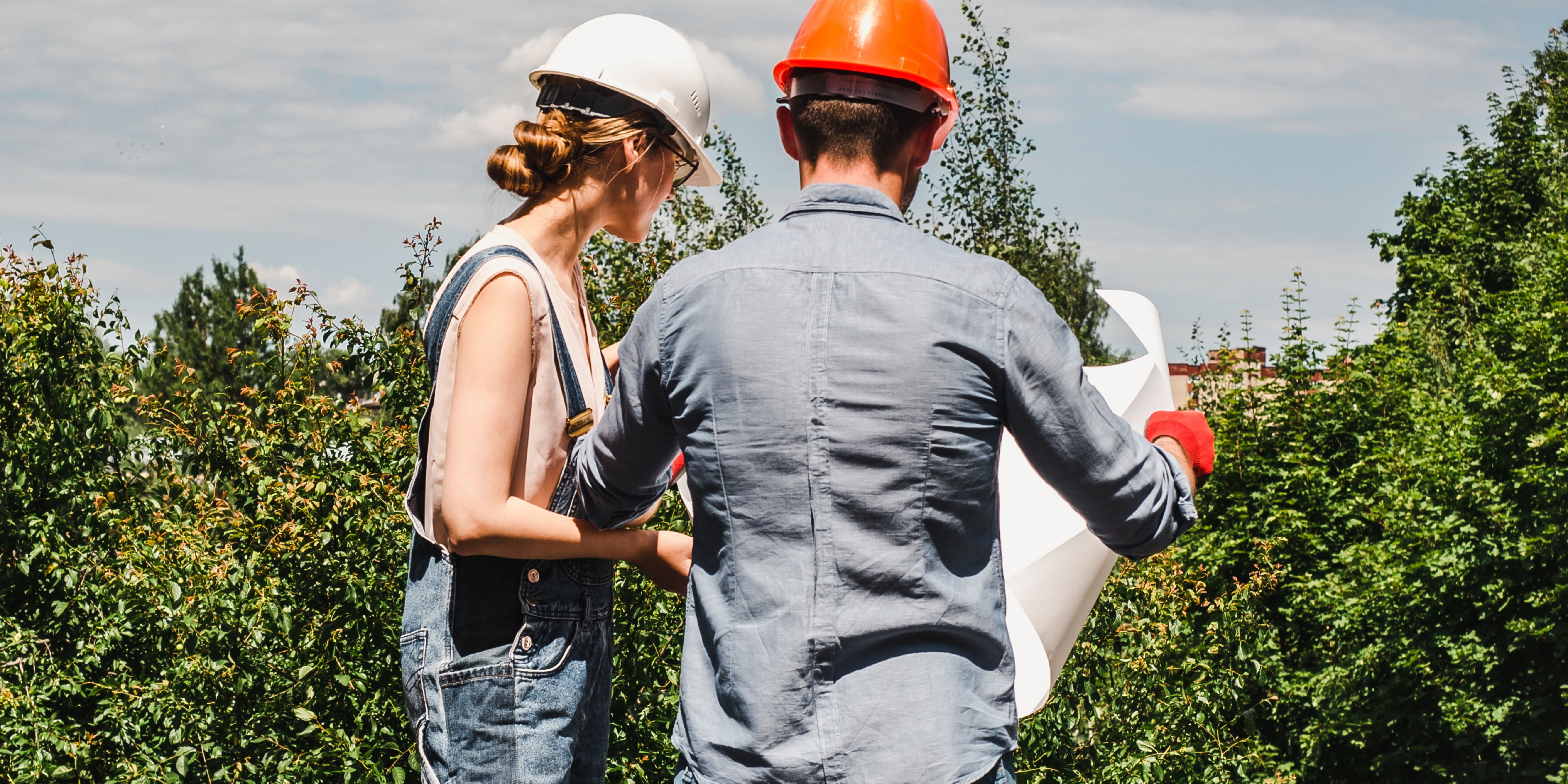 Two people with hard hats looking at paper