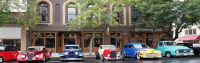 "street scene with cars lined up for car show "