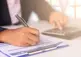 alt="hand writing on clipboard"