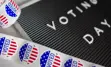 alt="Voting today sign and voted stickers."