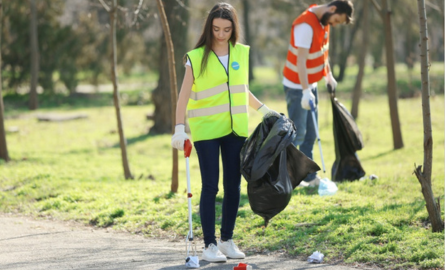 alt="woman grabbing litter off street"